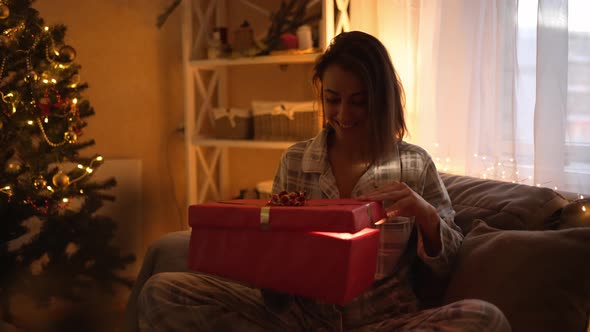 Slow Motion Happy Overjoyed Pretty Woman Opening Christmas Gift Box on Xmas Time Celebration at Home