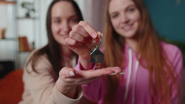 Girls Siblings Homeowners Hugging and Showing New Home Apartment Keys Receiving Mortgage Loan