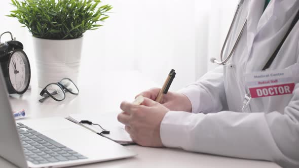 Unrecognizable Woman Doctor Sitting at Desk Checking Medicine Test Tubes Fill