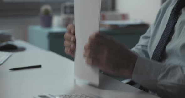 Corporate business executive sitting at desk and checking paperwork