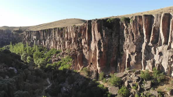 Aerial Deep Long Rift Canyon with Cleft Steep Rock Walls and High Cliff Gorge