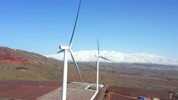 Wind turbines spin in a rural mountain landscape, Aerial view.