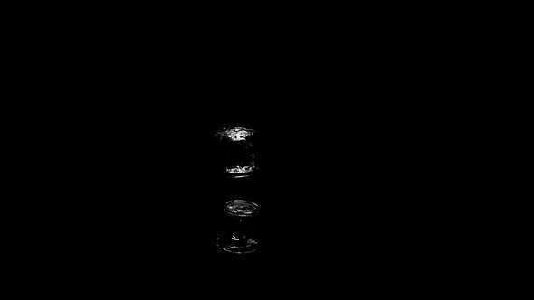 A Glass Of Water Falls , Splashes Spill Over The Surface On A Black Background alt