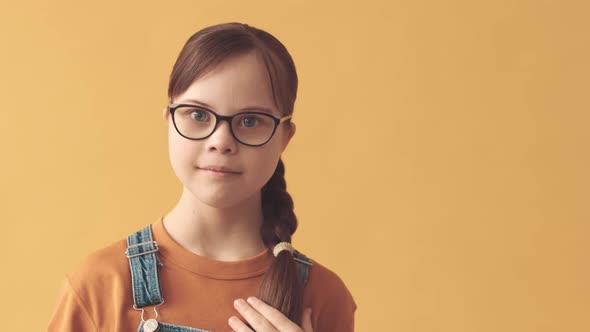 Portrait of Girl with Down Syndrome on Orange Background