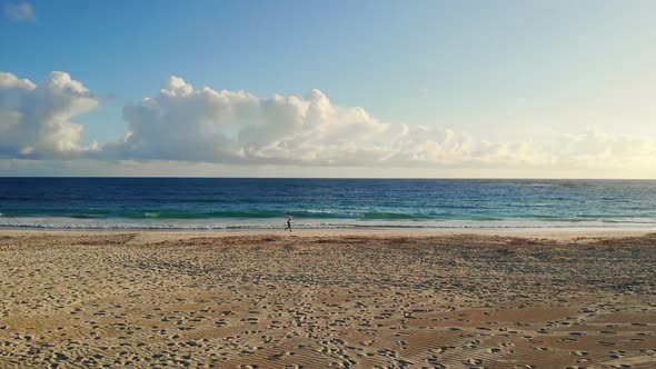 Runner Run Along the Coast of Ocean at Sunrise