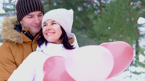 Man and woman in love kissing and hugging on outdoor date in winter