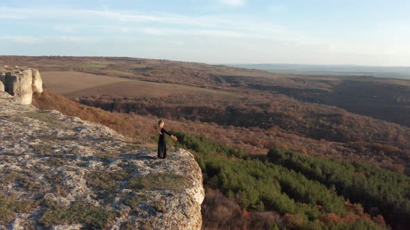 Woman standing at the edge of stunning rock