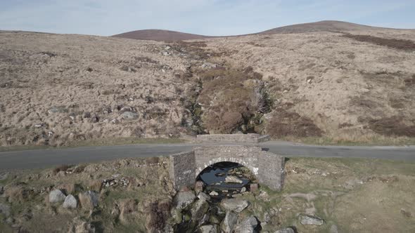 PS I Love You Bridge Across Rocky Stream In Wicklow Mountains, Ireland. drone pullback