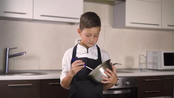 The Little Boy in a Suit of the Cook. Baby Make Dinner in Chef Suit