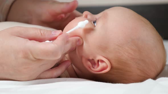 Mother Tries to Clean Wax From Ear of Baby with Cotton Swab