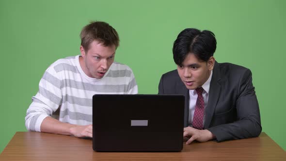 Young Asian Businessman and Young Scandinavian Businessman Working Together with Laptop