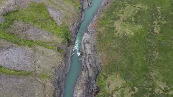 Aerial Shot Of Stream In Basalt Rock Columns In Studlagil Canyon, Eastern Iceland.