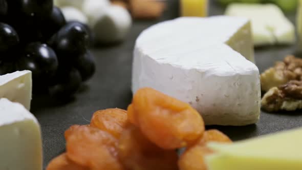 Assorted Different Types of Cheeses with Fruits, Nuts, Dried Fruits