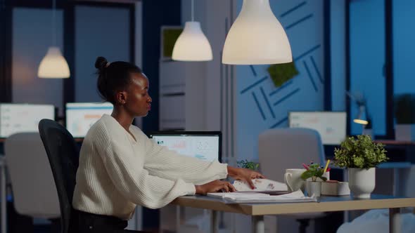 African Businesswoman Reading Business Reports From Laptop