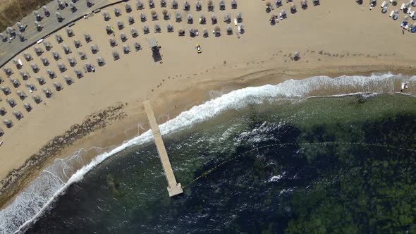 aerial shot above beach waves crashing