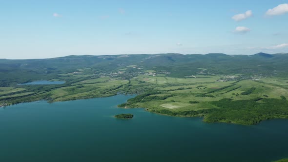 Aerial View on Water Reservoir at Mountain Valley Covered with Green Spring Forest