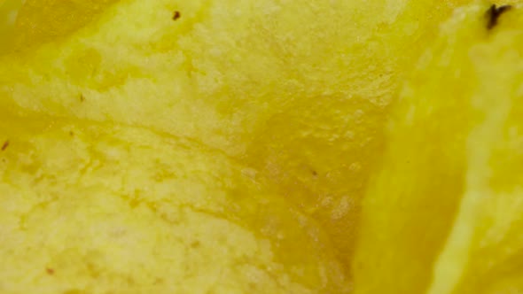 Very close up view of potato chips, macro shot in 4k. Rotating motion, texture video.