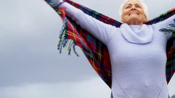 Happy senior woman standing on the beach