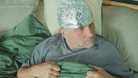 An Alarmed Man in a Foil Cap Suffering From Depression and Paranoia