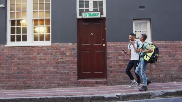 Two mixed race male friends walking and looking for hostel in the street