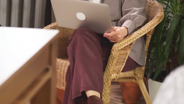 Gorgeous Elderly Businesswoman Happily Talking on Phone with Friend While Sitting with Laptop in