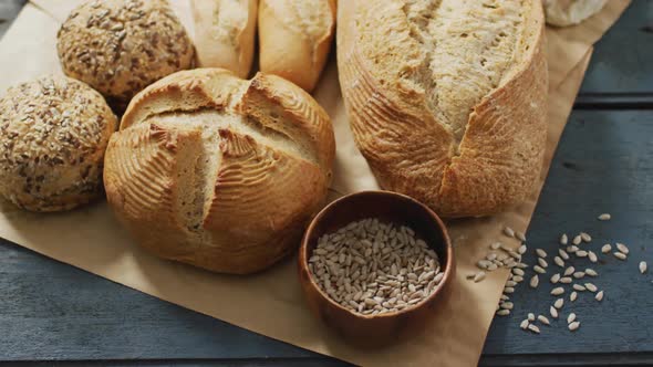 Video of rolls and bread on baking paper on wooden worktop