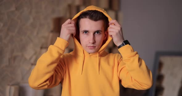 Man in Yellow Hoodie Puts on Hood at Home Slow Motion  at 120Fps