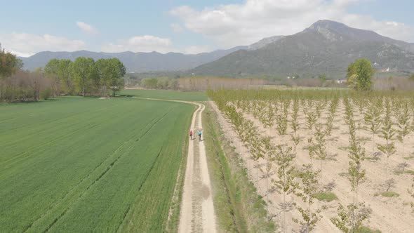 Couple having fun by riding mountain bike on dirt road in sunny day, scenic landscape of snowcapped