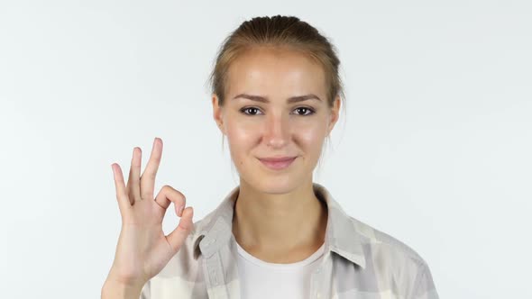 OK sign by a young girl in front of white background