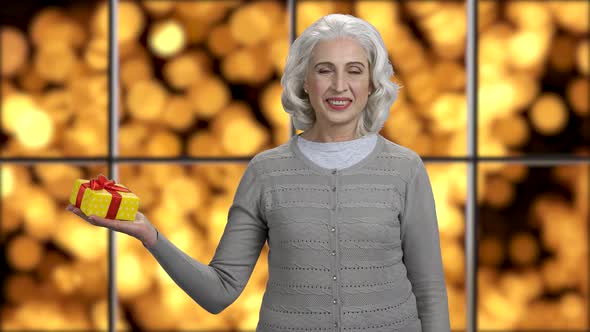 Happy Woman Holding Gift Box and Looking at Camera