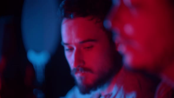 Man Playing Guitar and Another Singing in the Neon Lighting