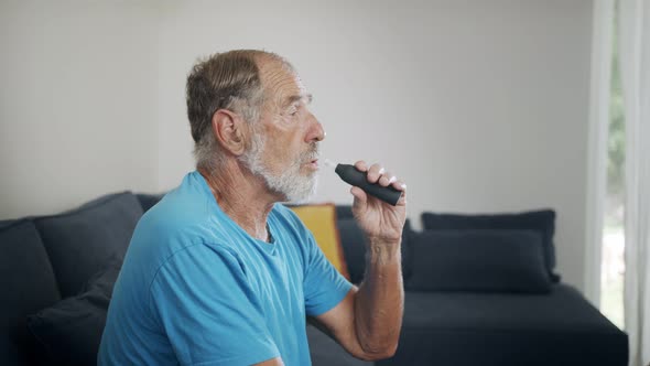 Man with Parkinson's disease using medical Cannabis in vaporizer to stop shaking