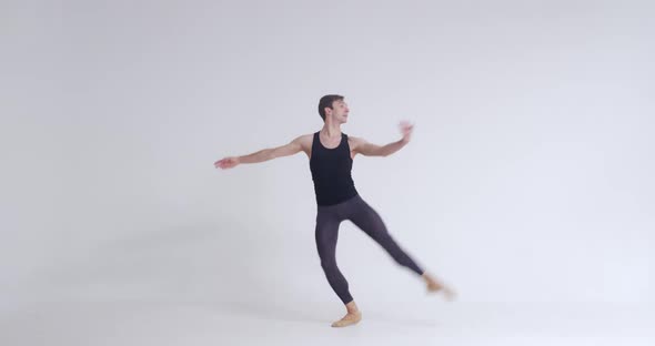 Elegant Male Ballet Dancer Performs Acrobatic Elements and Pirouette Ballet Dance on a White