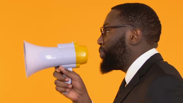 Afro-American Businessman Using Megaphone to Spread Information, Trade News
