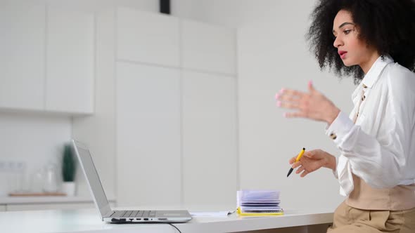 A Young Biracial Woman is Using a Laptop for Video Connection Indoor