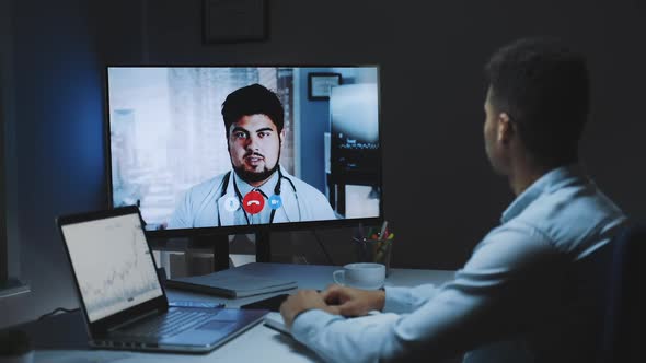 Back View of Young Man Making Video Call with Head Doctor About Coronavirus Spreading