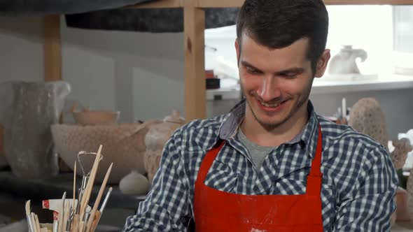 Handsome Cheerful Male Potter Enjoying Working at His Studio