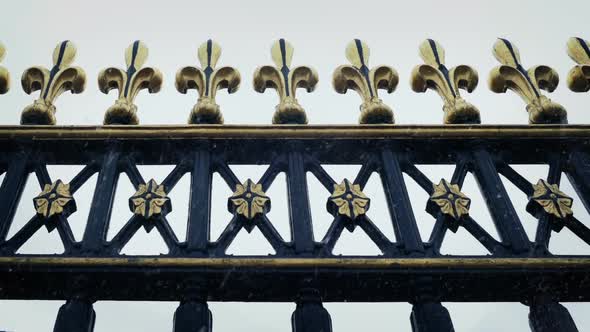 Passing Ornate Metal Railings With Snow Falling