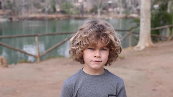 Boy in hoodie with wavy hair in daytime