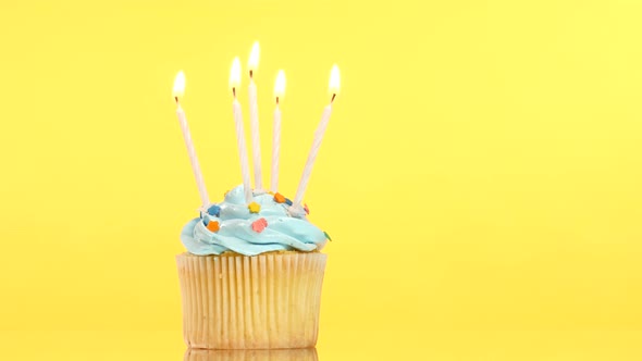 Tasty Birthday Cupcake with Five Candle, on Yellow Background
