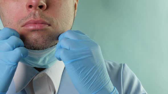 Doctor in Medical Suit with Stethoscope and Blue Gloves Put on and Off Protective Medic Mask