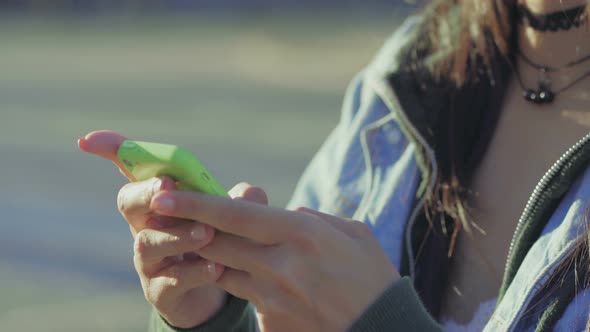 Closeup View of Female Hands Texting on Green Smartphone