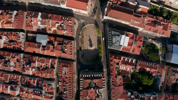 Descending Overhead Top Down Aerial View of Small Public Square with a Monument Surrounded By Red