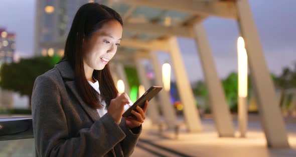 Business woman use of mobile phone in city at night