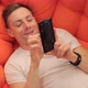 Man Looking at Photos on the Phone While Lying on the Couch - VideoHive Item for Sale