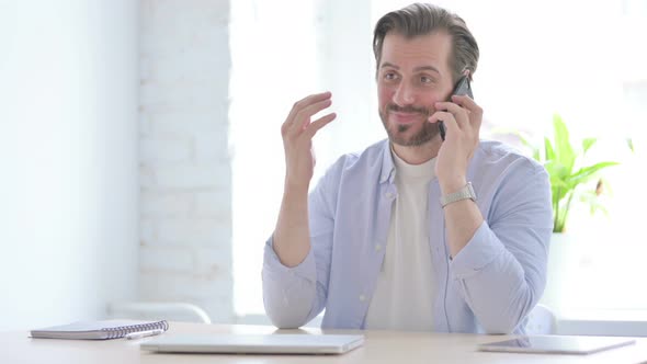 Young Man Talking on Phone in Office