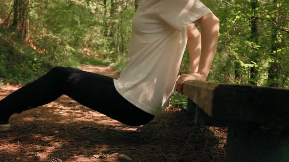 Close up of woman in sports clothes does a squat exercise.