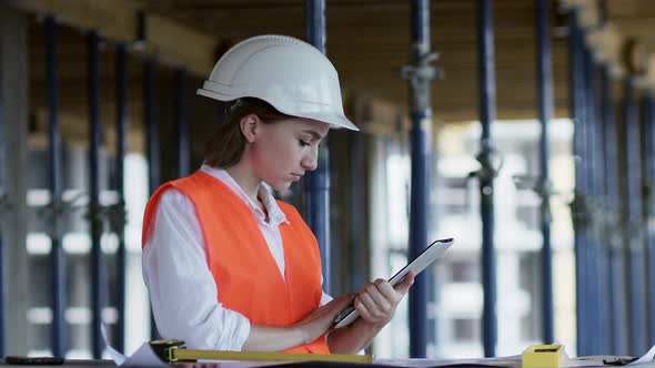 Engineer or Architect working at Construction Site. A woman with a tablet at a construction site.