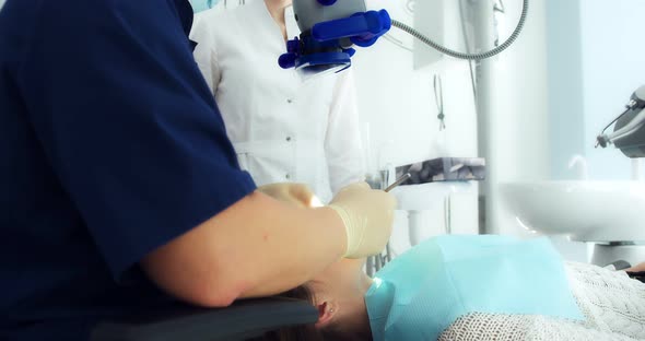 The Dentist Examines the Patient's Oral Cavity Using a Dental Mirror
