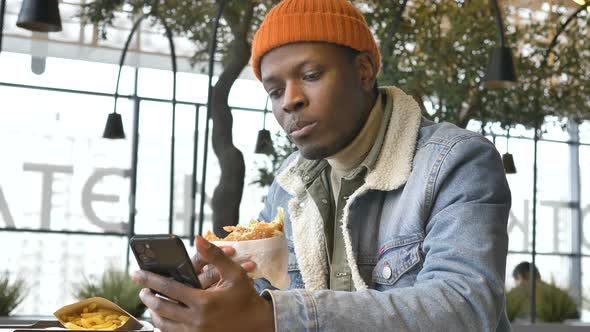 Concentrated Businessman in Jacket Eats Delicious Burger